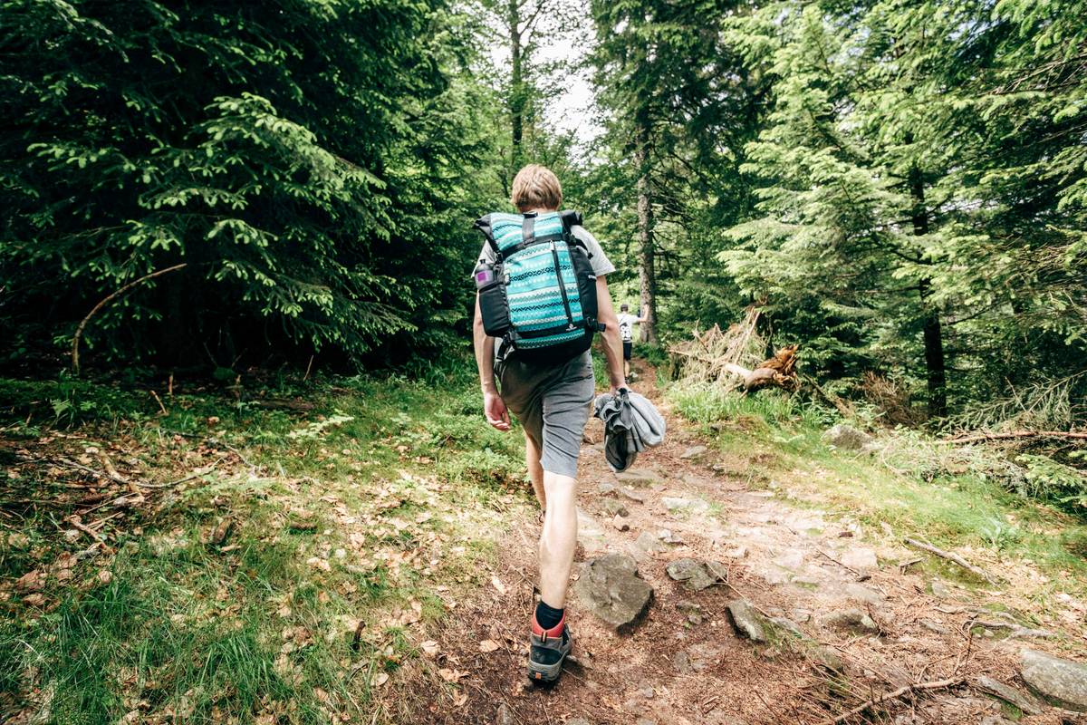 A person standing at a mountain peak after a hike