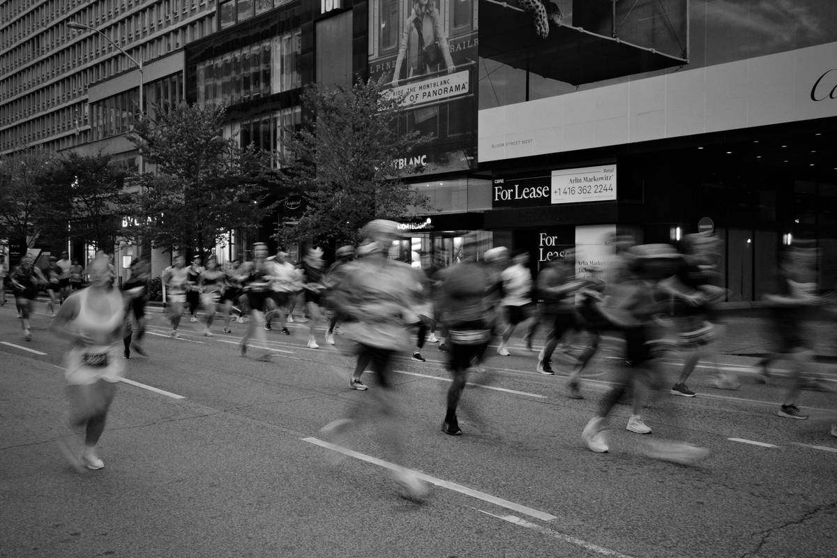Hikers crossing a stream using trekking poles.