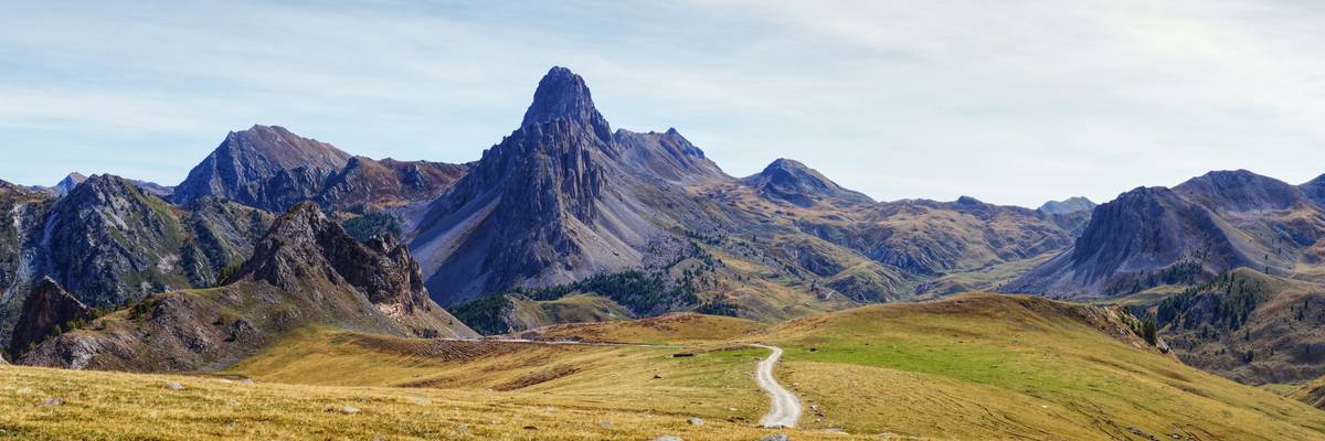 Smiling woman posing atop a mountain summit after completing a challenging hike.