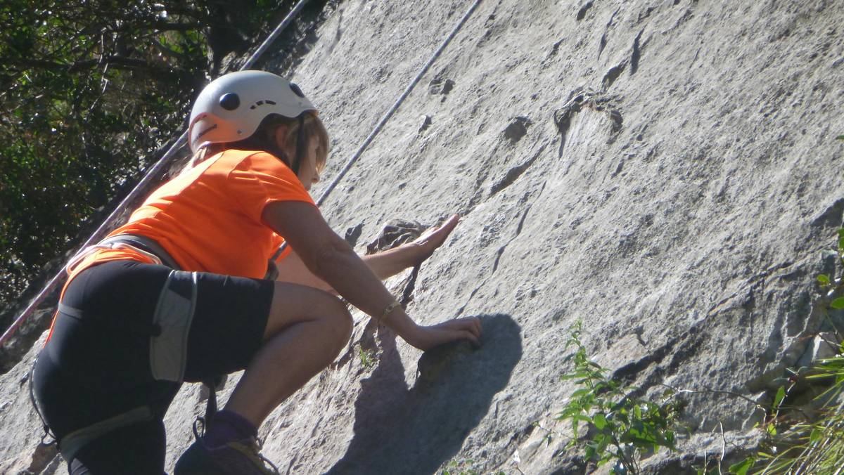 Smiling woman standing atop a peak after completing a challenging hike