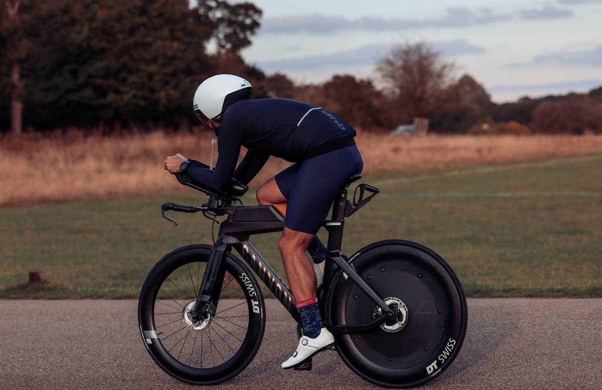 Smiling woman standing triumphantly atop a mountain summit after completing her hike.