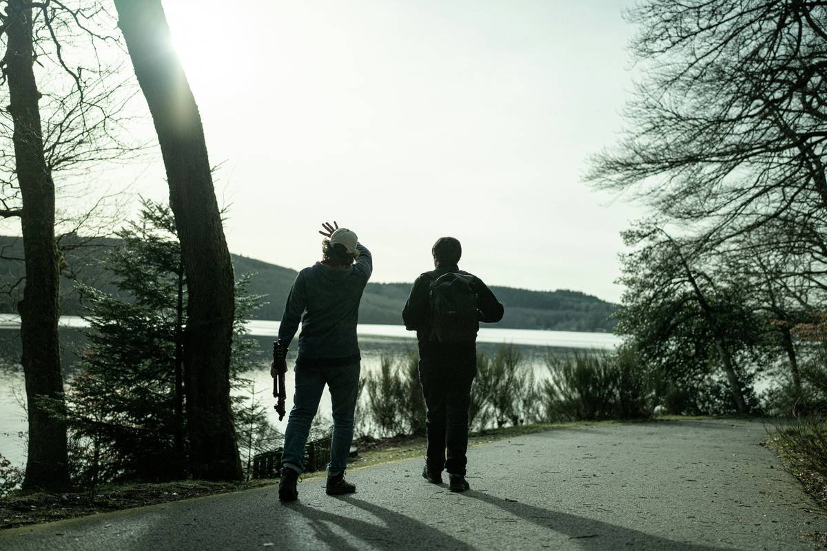 a couple of men standing next to each other on a road