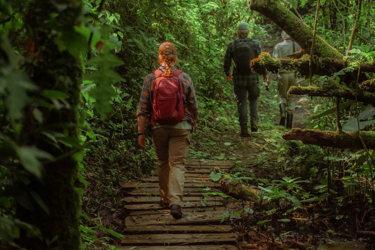 Woman hiking uphill with backpack showing outdoor burn hiking is a good fat loss method
